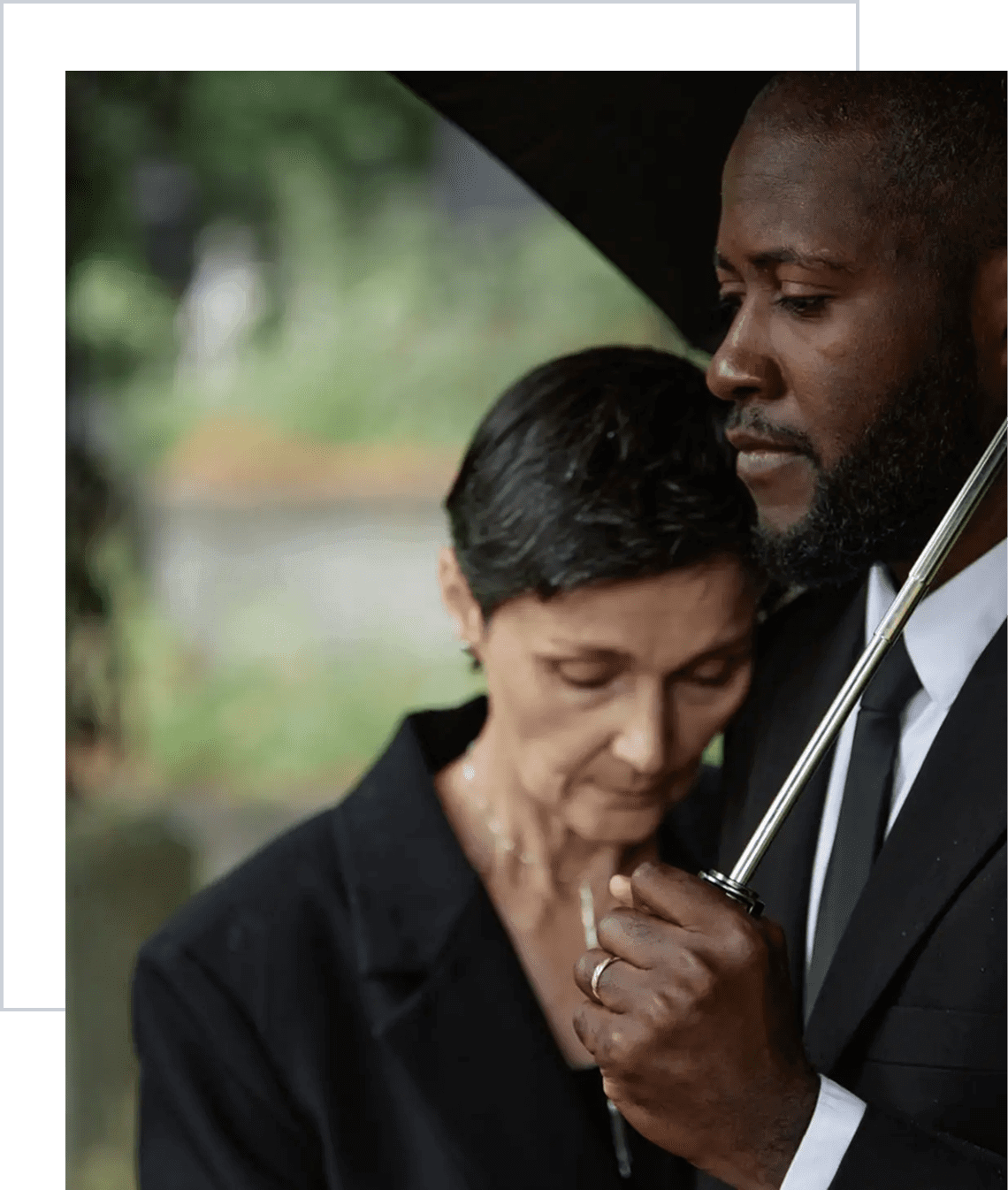 Man comforting woman under umbrella