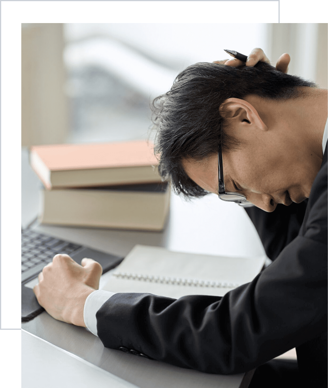 Overwhelmed businessman leaning on table